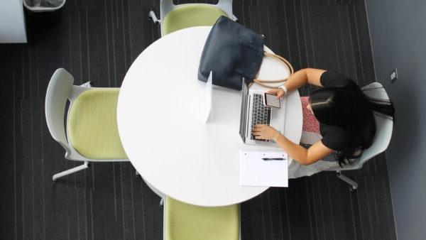 a person sitting at a table with a laptop