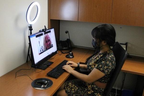 Woman sitting at a desk using a computer to try out the interview equipment at careers services